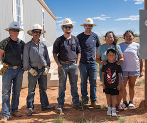 Light Up Navajo Colorado linecrew stands with a Navajo family that received electricity to their home.